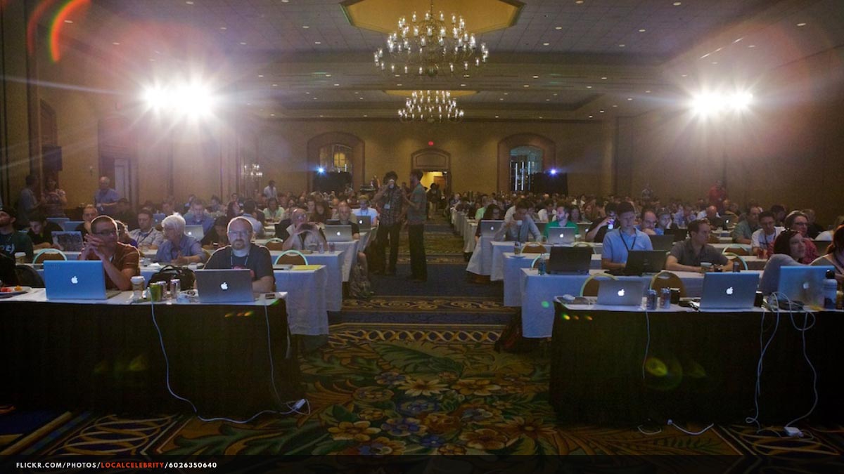 Photograph of a tech conference audience, taken from the speakers’ vantage point.