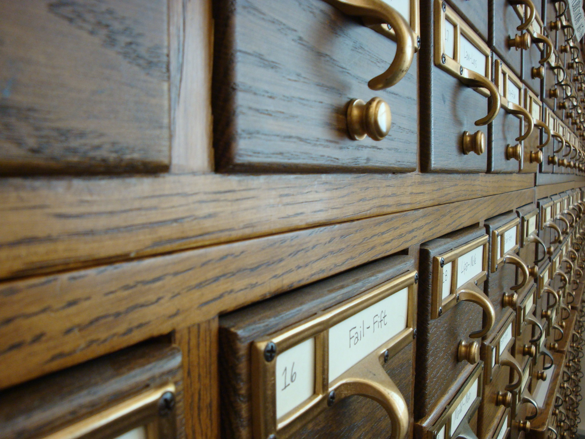 A close-up photograph of a card catalog with the numerous drawers spanning out beyond the frame